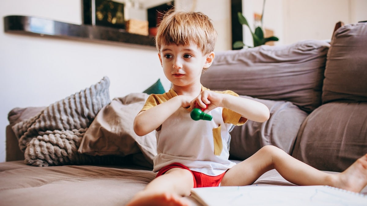 a young boy sitting on the floor playing with a toy